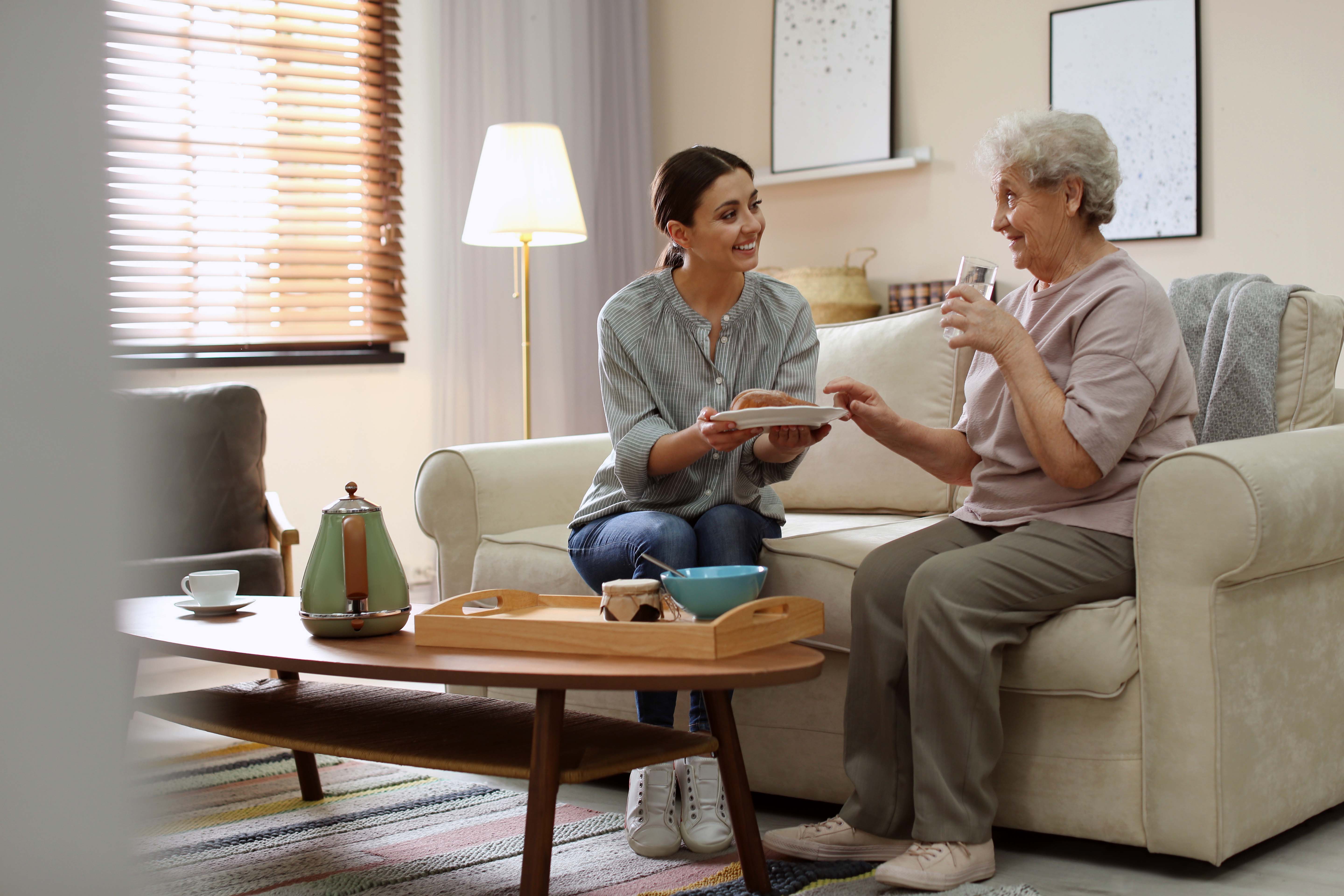 Noble Care carer sharing a warm moment with elderly client at home