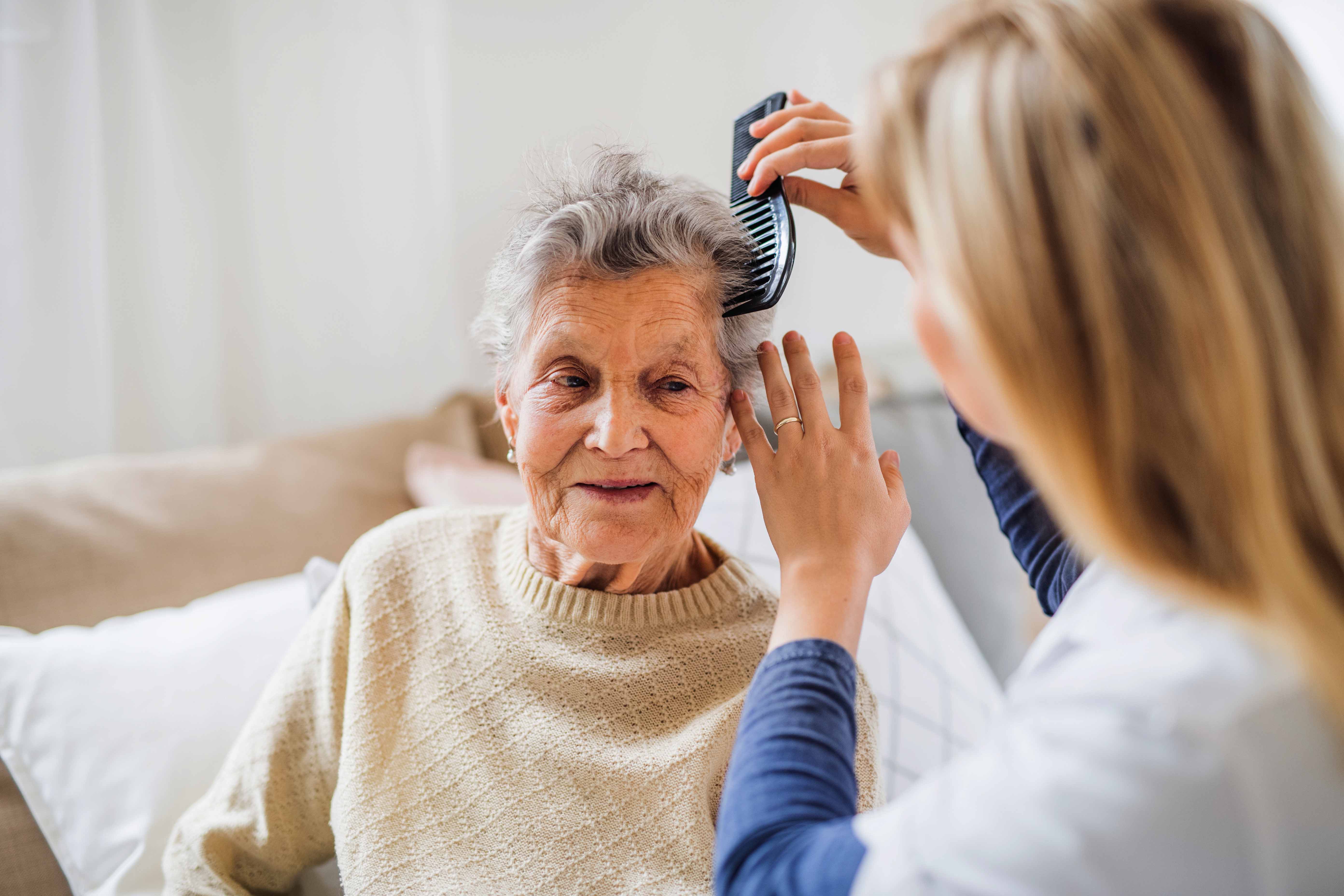 Noble Care carer providing personal care to elderly client at home